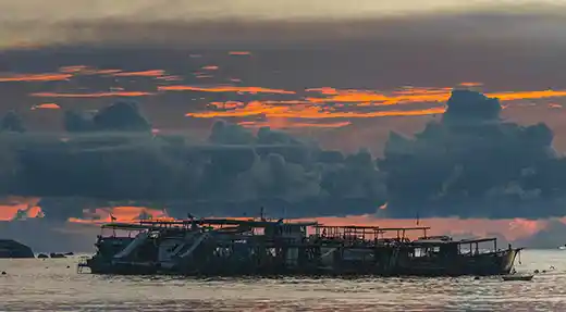 Three smiling fun divers wearing scuba gear on the Echo Divers boat in Koh Tao before a dive.