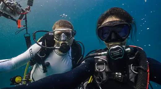 Two scuba divers enjoying a relaxed dive in the blue waters of Koh Tao with Echo Divers Koh Tao