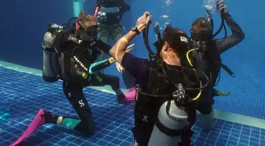 Divers practising scuba skills in a swimming pool during a scuba refresh in Koh Tao, Thailand