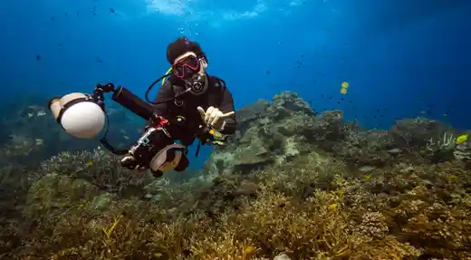 Fun diver exploring the HTMS Sattakut wreck in Koh Tao with Echo Divers, with other divers in the background.