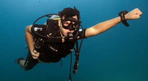  Diver posing in a playful “Superman” position underwater, photographed by Liquid Light Studio for Echo Divers Koh Tao. 