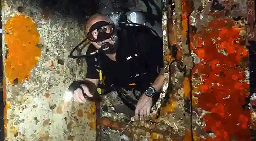 Echo Divers Koh Tao SSI Advanced Wreck Specialty diver inside a wreck using a guideline for safe navigation, Koh Tao, Thailand