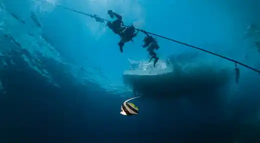 Echo Divers Koh Tao students descending on a line below the boat during a Basic Diver session in Koh Tao, Thailand