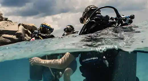 Two Echo Divers Koh Tao students holding hands underwater during a Basic Diver experience in Koh Tao, Thailand